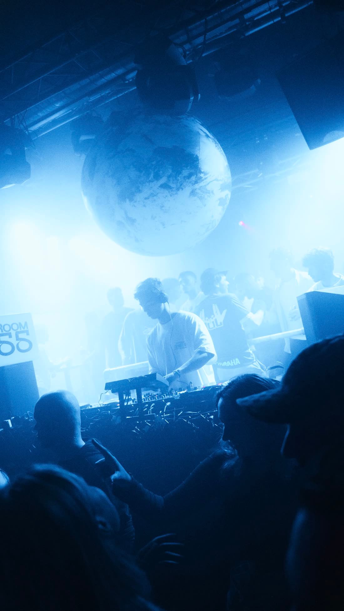DJ booth met wereldbol tijdens een Room55 nacht