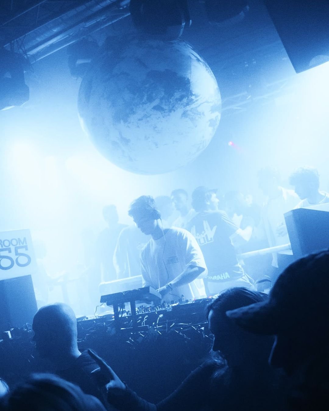 The real BaseYRD inflatable globe hanging above the DJ booth in blue light