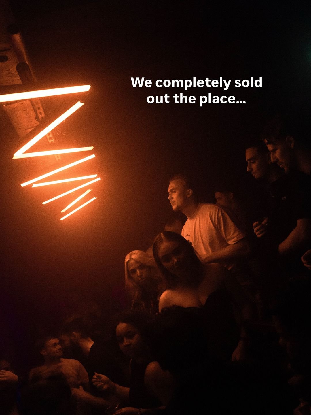 Sold-out floor under a red neon zigzag at Popup/Room55 in Dordrecht