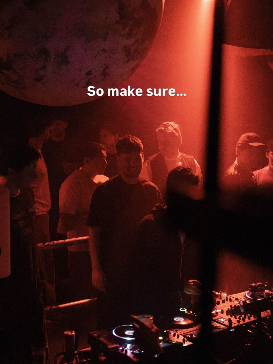 Crowd in red light next to the DJ booth at Popup/Room55 in Dordrecht